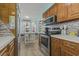 Well-lit kitchen with stainless steel oven, kitchen nook, and wooden cabinets at 6001 - 1308 S Kings Hwy., Myrtle Beach, SC 29575