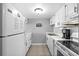 This well lit kitchen features white cabinets and appliances and neutral paint and flooring at 601 Mitchell Dr. # 808, Myrtle Beach, SC 29577