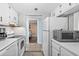 Galley style kitchen has white cabinets and appliances and an opening that looks into bedroom at 601 Mitchell Dr. # 808, Myrtle Beach, SC 29577