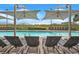 Outdoor pool with lounge chairs and shade umbrellas, set against a backdrop of beach vegetation at 603 S Ocean Blvd. # 1004, North Myrtle Beach, SC 29582