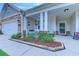 Inviting front porch with stone accents and a cozy seating area, enhanced by well-maintained landscaping at 676 Lafayette Park Dr., Little River, SC 29566