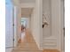 Bright hallway featuring hardwood floors, built-in bench, and a view into the dining room area at 676 Lafayette Park Dr., Little River, SC 29566