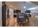 Open concept kitchen with dark wood cabinets, stainless appliances, breakfast bar, and wood flooring at 676 Lafayette Park Dr., Little River, SC 29566