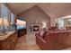 Spacious living area with a stone fireplace, vaulted ceiling, and leather furniture with bright natural light at 676 Lafayette Park Dr., Little River, SC 29566