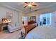 Cozy main bedroom showcasing tray ceiling, wood furnishings, seating area, and en-suite bathroom at 676 Lafayette Park Dr., Little River, SC 29566