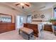Large main bedroom featuring a tray ceiling, wood furniture, and a glimpse into the en-suite bathroom at 676 Lafayette Park Dr., Little River, SC 29566