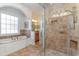 Primary bathroom featuring walk-in shower, separate tub, and tiled walls at 80 Stonington Dr., Murrells Inlet, SC 29576