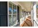 Covered porch featuring classic columns, wood flooring, and charming black shutters and lanterns at 80 Stonington Dr., Murrells Inlet, SC 29576