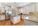 Kitchen with stainless steel refrigerator, granite counters, an island, and white cabinets and trim at 80 Stonington Dr., Murrells Inlet, SC 29576