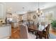 Bright kitchen and dining area with wooden table, chandelier, stainless steel appliances, and hardwood flooring at 80 Stonington Dr., Murrells Inlet, SC 29576