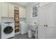 Bright laundry room with front load washer and dryer, ample shelving, and a utility sink at 80 Stonington Dr., Murrells Inlet, SC 29576