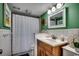 This bathroom features green walls, a vanity, and a shower with a white curtain at 806 Conway St. # 309, North Myrtle Beach, SC 29582