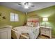 A bedroom with a window and a ceiling fan. Coastal decor and green walls at 806 Conway St. # 309, North Myrtle Beach, SC 29582