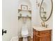 Elegant powder room with a decorative mirror, marble countertop, and custom shelves at 8285 Leone Circle, Myrtle Beach, SC 29579