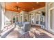 Covered outdoor patio with brick floors, ceiling fan, and cozy seating area at 8285 Leone Circle, Myrtle Beach, SC 29579