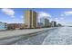 Gorgeous beachfront featuring towering condo buildings and inviting sandy shores with rolling ocean waves at 900 N Waccamaw Dr. # 303, Murrells Inlet, SC 29576