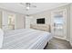 Bright bedroom with light walls, a ceiling fan, and a door leading to a private balcony with ocean views at 900 N Waccamaw Dr. # 303, Murrells Inlet, SC 29576