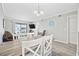 Open dining area with rustic wood table, white chairs, chandelier, and access to a balcony at 900 N Waccamaw Dr. # 303, Murrells Inlet, SC 29576