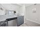 Modern kitchen featuring stainless steel dishwasher, gray cabinets, and light countertops open to the living room at 900 N Waccamaw Dr. # 303, Murrells Inlet, SC 29576