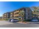 Multi-story condo building featuring screened porches, lush landscaping, and ample parking at 9501 Shore Dr. # A-314, Myrtle Beach, SC 29572