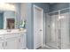 Bright bathroom featuring a glass-enclosed shower and a white vanity with storage at 104 Fair Meadow Ct., Loris, SC 29569