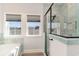 A modern bathroom highlighting a glass-enclosed shower with a rainfall showerhead, a soaking tub, and bright natural light at 1042 Muscovy Pl., Conway, SC 29526