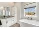 Bathroom with a white cabinet vanity and granite countertops. Next to the freestanding tub is a large window with an outdoor view at 1042 Muscovy Pl., Conway, SC 29526