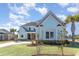 Stunning two-story home with a light blue exterior, stone accents, landscaped yard, and mature palm trees at 1042 Muscovy Pl., Conway, SC 29526