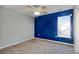 Comfortable bedroom with neutral carpet, a ceiling fan, and a bright blue accent wall at 105 Wagon Wheel Ln., Surfside Beach, SC 29575