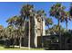 Unique brick tower with palm trees around the perimeter of a lush landscaped yard at 1064 Jase Dr., Longs, SC 29568