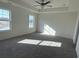 Spacious main bedroom featuring neutral walls and carpet, two windows and a ceiling fan at 1064 Jase Dr., Longs, SC 29568