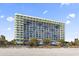 This exterior shot of the condo shows the large building with many balconies overlooking the ocean and beach at 1105 S Ocean Blvd. # 604, Myrtle Beach, SC 29577