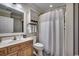 Well-lit bathroom with a shower featuring a curtain, and a wooden vanity with a sink and a decorative mirror at 123 Avian Dr. # 102, Pawleys Island, SC 29585