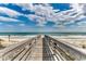 Wooden walkway to a pristine beach with clear blue water and sky at 123 Avian Dr. # 102, Pawleys Island, SC 29585