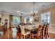 Elegant dining room boasts hardwood floors and a chandelier over a wooden table set for a meal at 123 Avian Dr. # 102, Pawleys Island, SC 29585