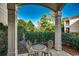 Charming outdoor patio with seating, framed by manicured hedges and lush landscaping, pillars and blue sky at 123 Avian Dr. # 102, Pawleys Island, SC 29585