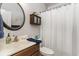 Neat bathroom featuring single vanity, round mirror, and shower with white curtain at 129 Tomoka Trail, Longs, SC 29568