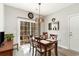 Bright dining area with a sliding glass door, modern lighting, and wood-look floors at 129 Tomoka Trail, Longs, SC 29568