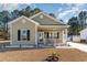 Inviting single-story home featuring a charming front porch and well-maintained yard at 129 Tomoka Trail, Longs, SC 29568