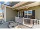 Charming front porch with white railing, rocking chairs, and a cozy atmosphere at 129 Tomoka Trail, Longs, SC 29568