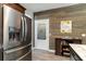 Bright kitchen featuring stainless steel refrigerator and wood-paneled accent wall at 129 Tomoka Trail, Longs, SC 29568