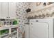 Well-organized laundry room with floral wallpaper, storage cabinets, and a Maytag washer and dryer at 129 Tomoka Trail, Longs, SC 29568