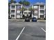 Well-maintained condo building with brick accents, balconies and plentiful parking on a bright day at 1298 River Oaks Dr. # 5-F, Myrtle Beach, SC 29579
