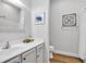 Cozy bathroom featuring a single sink vanity, framed art, and shower with a glass door at 140 Northside Dr., Little River, SC 29566