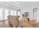 Inviting living room with plush seating, modern TV, and access to outdoor spaces through elegant glass doors at 140 Northside Dr., Little River, SC 29566