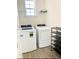 Bright laundry area featuring a modern washer, dryer, shelving, and wood-look flooring at 162 Mountain Ash Ln., Myrtle Beach, SC 29579