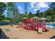 A well-equipped playground is set against the backdrop of a serene lake and lush greenery at 162 Mountain Ash Ln., Myrtle Beach, SC 29579