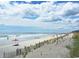 Picturesque beach view with soft sand and gentle waves under a partly cloudy sky at 172 Hawthorn Dr., Pawleys Island, SC 29585