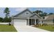 Charming home featuring horizontal siding, a pristine white garage door, and well-manicured green lawn at 1833 Hardwood Ct., Conway, SC 29526