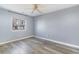 Bright bedroom with grey walls, wood floors, and a window offering a view of the neighborhood at 1881 Colony Dr. # 8-S, Surfside Beach, SC 29575